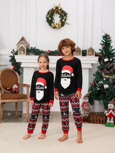 Kids' Christmas pajamas with Santa Claus print in a cozy holiday home setting