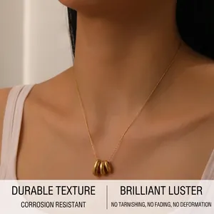 Détail d'un collier géométrique à maillons dorés porté par un mannequin chic