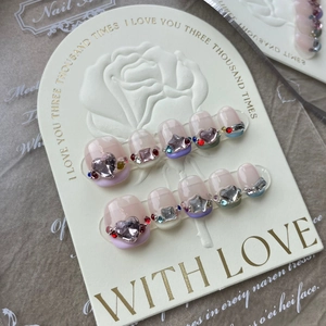 Detailed view of handmade press-on nails with 3D crystals and heart rhinestones