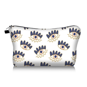 Detail of evil eye printed makeup bag featuring white canvas and black zipper closure