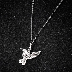 Detailed view of silver stainless steel origami hummingbird pendant on black background