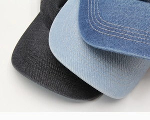 Detail of denim baseball cap showing precision stitching and washed cotton texture