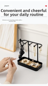 Close-up of black metal jewelry stand with wooden base tray for necklaces and earrings