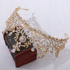 Detailed close-up of a vintage gold bridal crown with AAA zircons on a wooden gift box