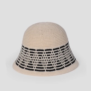 Close-up of beige knitted bucket hat with black geometric jacquard pattern texture