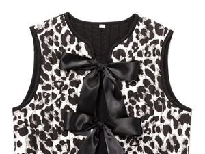 Detail of black and white leopard print quilted vest with elegant black satin bow ties