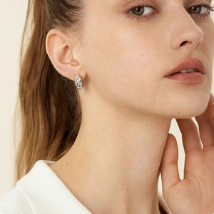 Silver twisted woven hoop earrings for women with a minimalist luxury design shown on model