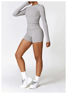 Détail d'ensemble yoga gris avec passe-pouces aux manches et short de fitness taille haute