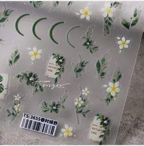Macro view of embossed nail stickers featuring white flowers and green leaves on clear film