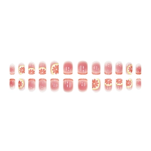 Pink gradient press-on nails with realistic orange fruit patterns and glossy finish