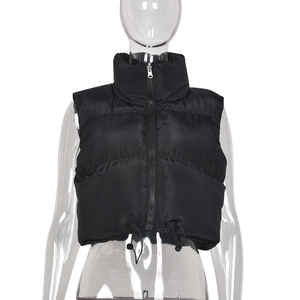 Detail view of black cropped puffer vest with stand collar, zipper and drawstring hem