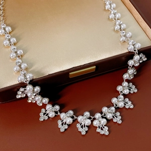 Gros plan d'un collier de perles et de strass dans une boîte à bijoux vintage