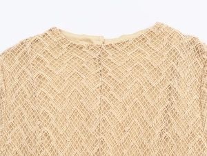Detailed view of beige hollow-out knit lace fabric with diamond mesh texture and round neck