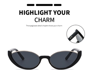Detail of cat eye sunglasses with glossy black frames and gold metal accents on corners