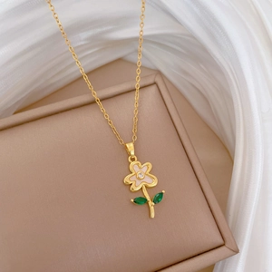 Luxurious gold flower necklace with pink petals and green leaf crystals on satin