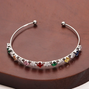 Close-up of silver-tone rainbow gemstone cuff bracelet with polished finish
