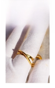 Macro shot of gold criss-cross irregular layered ring showing polished metal texture