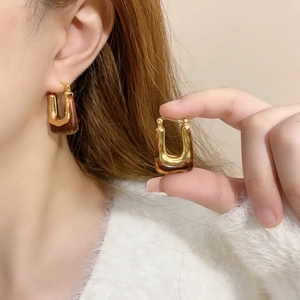 Vintage U-shape gold-plated resin hoop earrings with amber texture on model