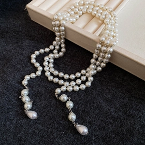 Close-up of multi-layer pearl necklace with elegant water drop pendants and tassel detail