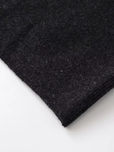 Detailed close-up showing the soft knitted texture and layered fold of this black midi skirt