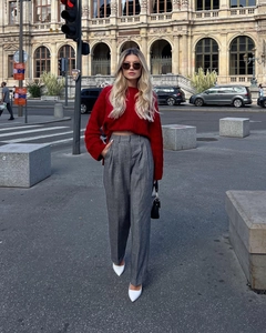 Detail showing red oversized knit sweater texture and grey wide-leg trousers styling