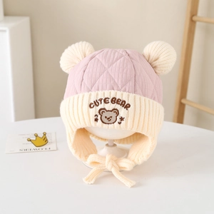 Close-up of pink cute bear embroidery and quilted texture on toddler winter hat