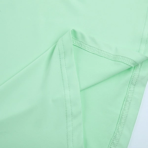 Détail d'une robe vert menthe montrant l'ourlet à double couture et le tricot doux