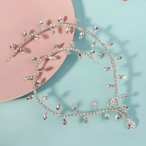 Silver bridal forehead chain with leaf rhinestones and waterdrop pendant on soft background