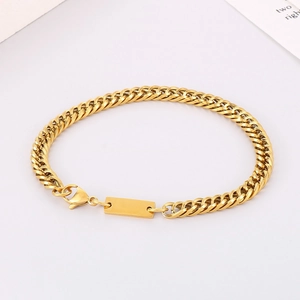 Detailed view of a gold-toned Cuban link bracelet featuring a rectangular ID engraving plate