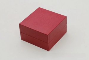 Macro shot of red leather textured watch box featuring a square flip-top cover design
