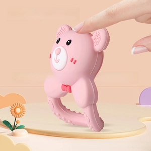 Pink silicone baby teether in bear shape showing flexible and squeeze material texture