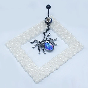 Macro detail of gothic spider belly ring featuring iridescent teardrop zircon stone