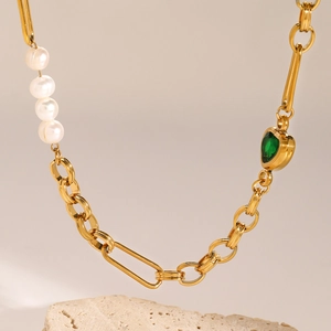 Gold stainless steel pearl necklace featuring a green heart gemstone pendant on stone pedestal