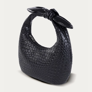 Detail der schwarzen PU-Handtasche mit gewebter Textur und geknotetem Griff-Design