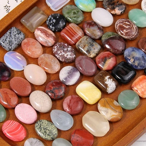 Mix of vintage geometric natural stone beads and cabochons on a wooden display tray