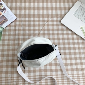 Vue de dessus de l'intérieur d'un sac bandoulière blanc avec doublure noire et fermeture éclair