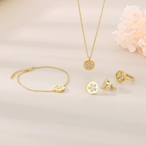 Detail view of gold flower jewelry set featuring heart petals and clover patterns