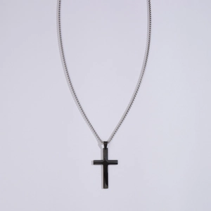 Polished black cross pendant necklace with silver steel chain on white background