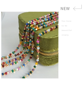Close-up of multicolor faceted beaded necklace on premium olive green velvet jewelry box