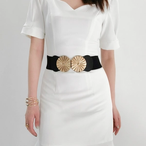 Close-up of wide black elastic waist belt with large golden round sunburst buckle