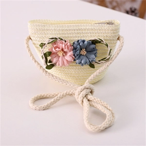 Detailed view of handmade straw bag with fabric flowers and cotton rope strap