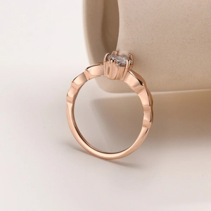 Close-up of rose gold ring featuring a four-prong set round zircon and wavy textured band