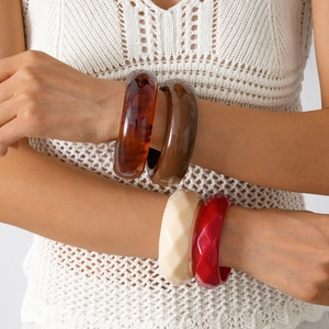 Acrylic resin geometric bangle set featuring amber, brown, cream, and red faceted styles