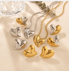 Flat lay of heart-shaped gold and silver mixed-metal earrings and necklaces set