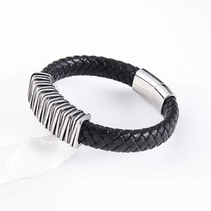 Macro detail of men's black braided leather bracelet with magnetic silver metal clasp
