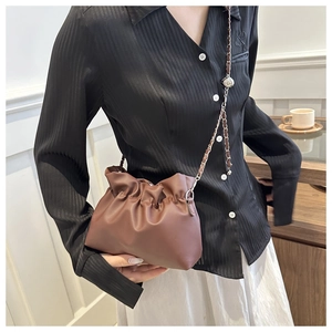 Detail showing dark brown pleated PU leather crossbody bag with silver chain strap