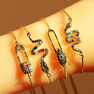 Close-up of gold safety pin bracelet with colorful cubic zirconia and sliding clasp