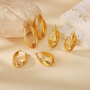 Detailed view of three-tier golden wavy hoop earrings in small, medium and large sizes