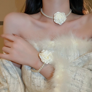 Gros plan sur l'ensemble collier et bracelet en perles avec breloque rose en tissu