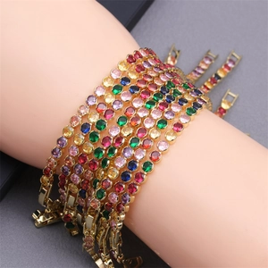 Detail of colorful round-cut crystal tennis bracelets in gold plating on wrist